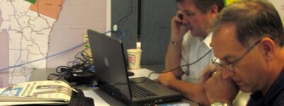 People at a cluttered desk on phones